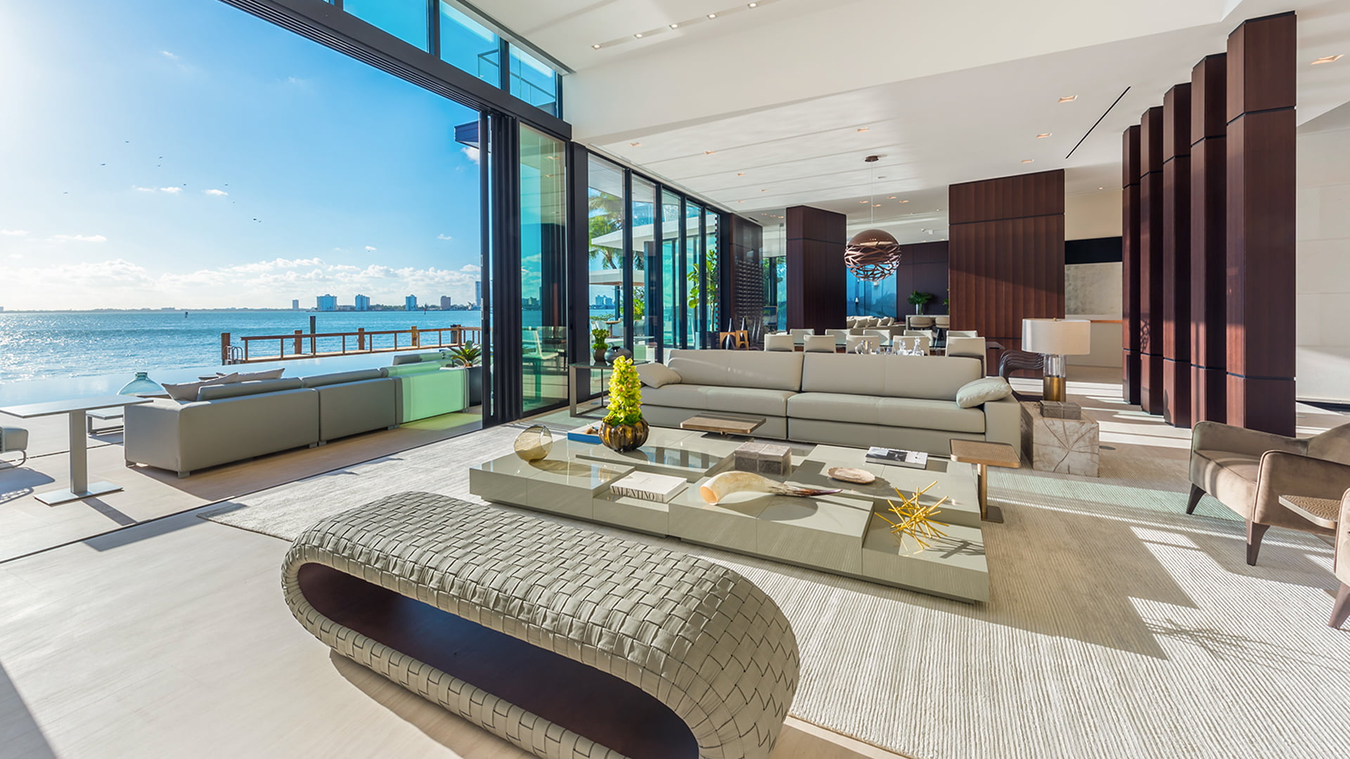 Modern, spacious living room with large windows in Miamis La Gorce Residence, neutral furniture, and ocean views.